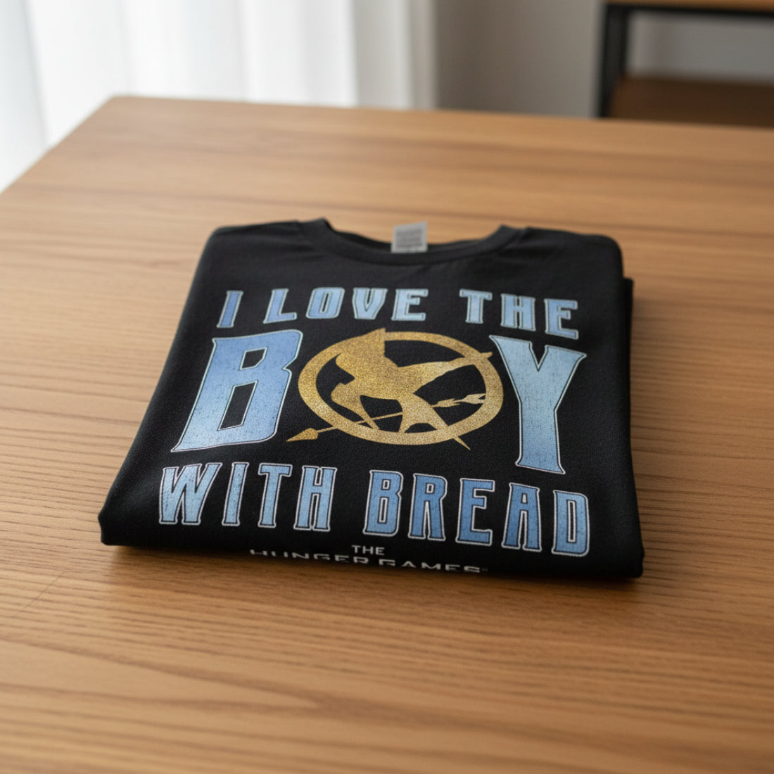 FOLDED Black t-shirt with 'I Love the Boy with Bread' text and Hunger Games logo HGAM584S, HGAM584M, HGAM584L, HGAM584XL, HGAM584XXL, HGAM584XXXL, HGAM584XXXXL, HGAM584XXXXXL