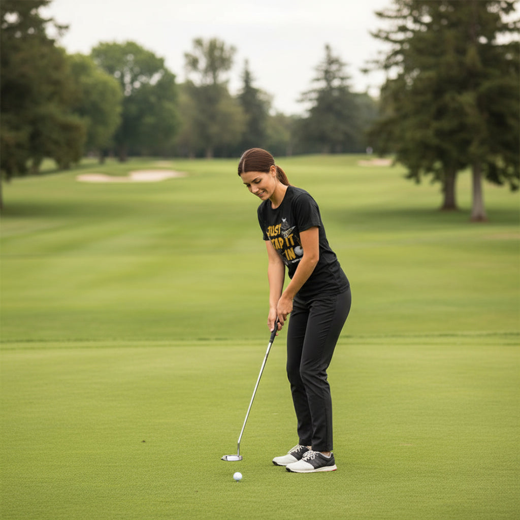 Woman wearing Black t-shirt with 'Just Tap It In' graphic and 'Happy Gilmore' text HGIL548S, HGIL548M, HGIL548L, HGIL548XL, HGIL548XXL, HGIL548XXXL, HGIL548XXXXL, HGIL548XXXXXL