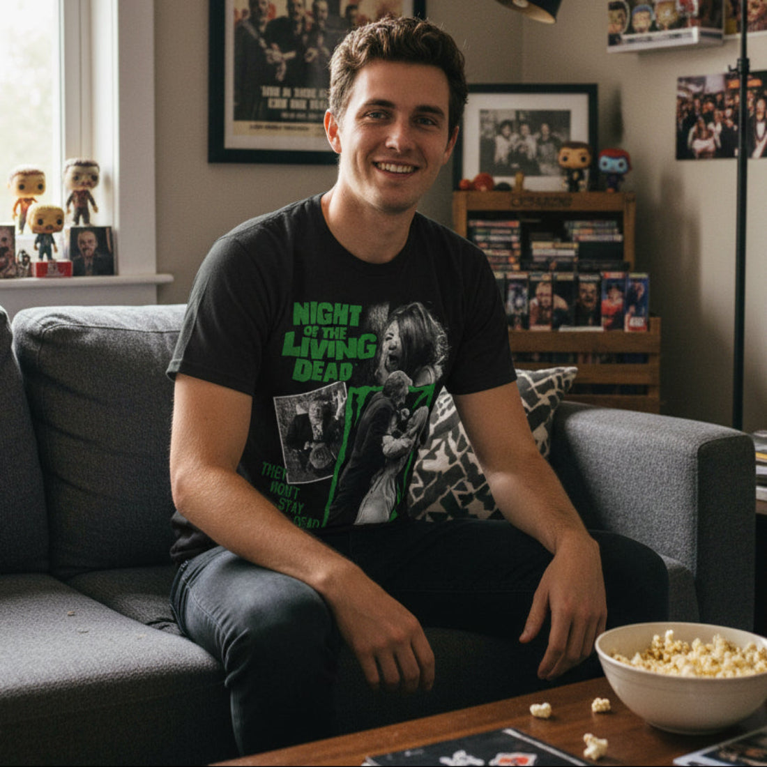 Man wearing Black t-shirt with 'Night of the Living Dead' graphic design featuring a woman and a man in a green frame. NLD511S, NLD511M, NLD511L, NLD511XL, NLD511XXL, NLD511XXXL, NLD511XXXXL, NLD511XXXXXL