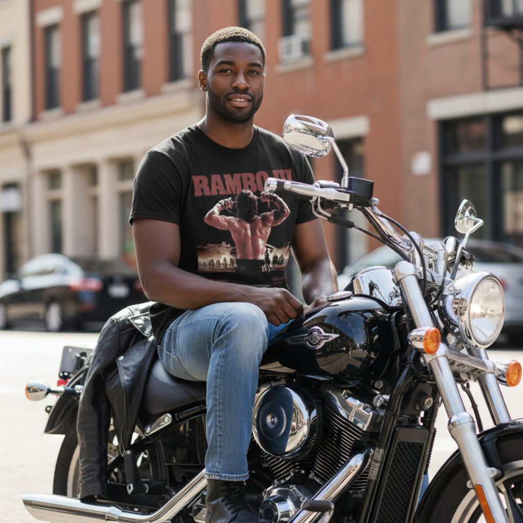 Man sitting on a motorcycle wearing Rambo tee in an urban setting RAM5110S, RAM5110M, RAM5110L, RAM5110XL, RAM5110XXL, RAM5110XXXL, RAM5110XXXXL, RAM5110XXXXXL