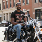 Man sitting on a motorcycle wearing Rambo tee in an urban setting RAM5110S, RAM5110M, RAM5110L, RAM5110XL, RAM5110XXL, RAM5110XXXL, RAM5110XXXXL, RAM5110XXXXXL