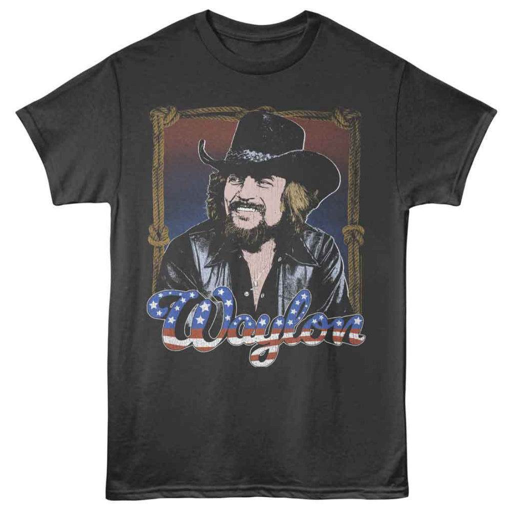 Black t-shirt with a graphic of Waylon Jennings in a cowboy hat and leather jacket, featuring the name 'Waylon' in American flag colors.