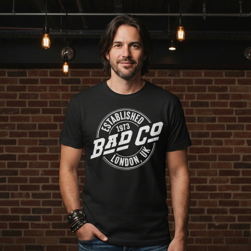 MAN WEARING Black t-shirt with 'Bad Co' logo on a white background BCO501S, BCO501M, BCO501L, BCO501XL, BCO501XXL, BCO501XXXL, BCO501XXXXL, BCO501XXXXXL