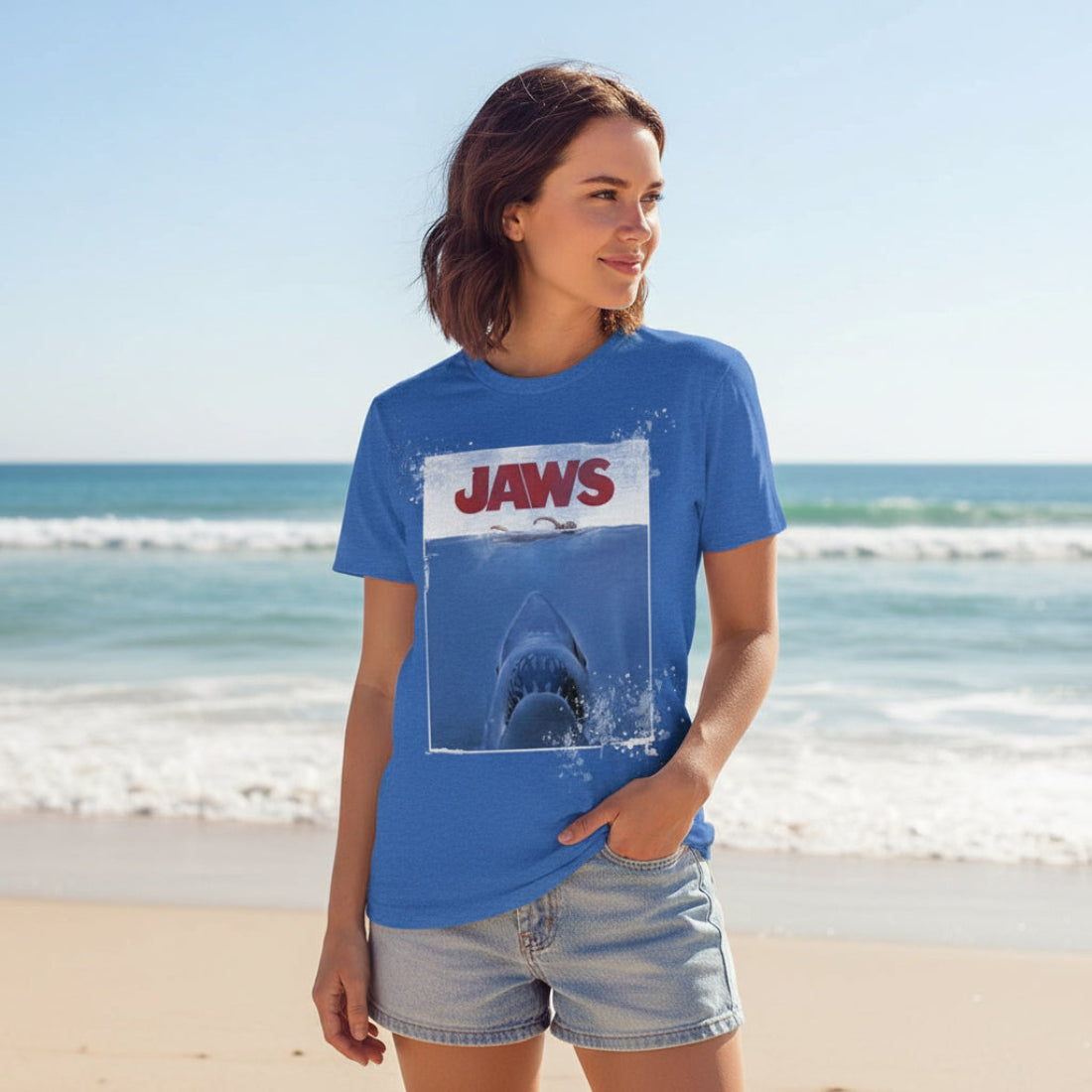 Woman wearing Blue t-shirt with 'JAWS' graphic and 'Amity Island 1975' JAW507S, JAW507M, JAW507L, JAW507XL, JAW507XXL, JAW507XXXL, JAW507XXXXL, JAW507XXXXXL
